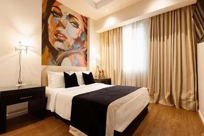a bedroom with a large bed with a painting on the wall at Best Western Plus Embassy Hotel in Athens
