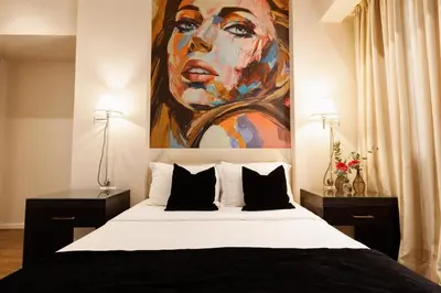 a bedroom with a large painting of a woman at Best Western Plus Embassy Hotel in Athens