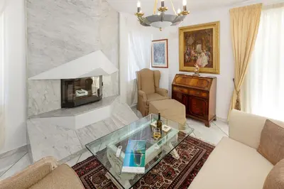 a living room with a fireplace and a table at Nice Sea View Elegant Apartment in Athens