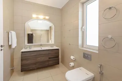 a bathroom with a sink and a toilet and a mirror at Nice Sea View Elegant Apartment in Athens