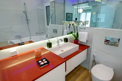 a white bathroom with a sink and a toilet at Frixos Acropolis Luxury Apartment in Athens