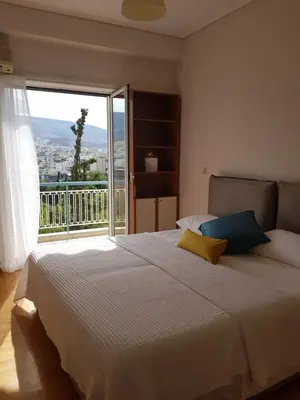 a bedroom with a large bed with a large window at Park at Home Apartment in Athens