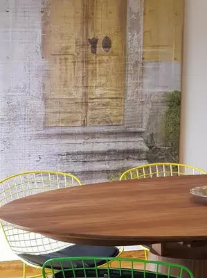 a wooden table with two chairs in front of a wall at Park at Home Apartment in Athens