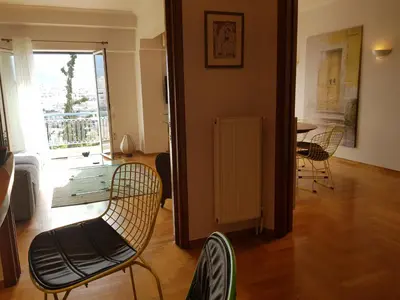 a living room with chairs and a table and a window at Park at Home Apartment in Athens