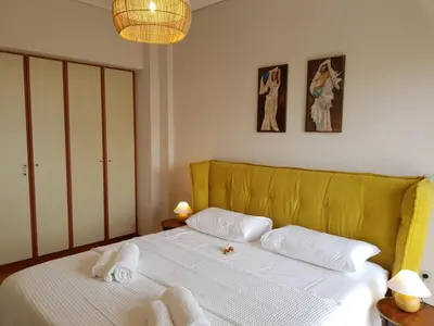 a bedroom with a white bed with towels on it at Park at Home Apartment in Athens