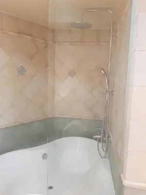 a shower with a glass door in a bathroom at Park at Home Apartment in Athens