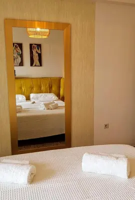 a reflection of a bedroom with two beds and a mirror at Park at Home Apartment in Athens