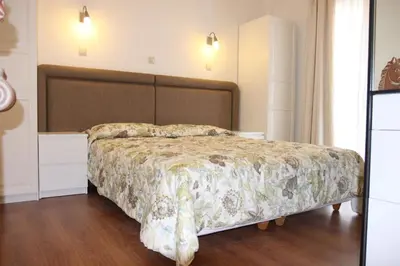 a bedroom with a bed with a floral bedspread at Be My Guest Apartment in Athens