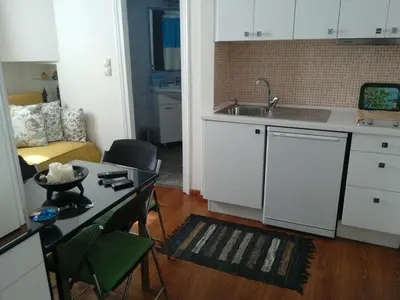 a kitchen with a sink and a table in a room at Be My Guest Apartment in Athens