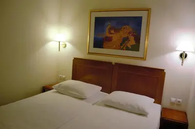 a bedroom with two beds and a painting on the wall at Hapimag Apartments Athens in Athens