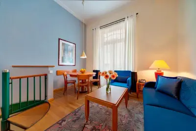 a living room with a blue couch and a table at Hapimag Apartments Athens in Athens