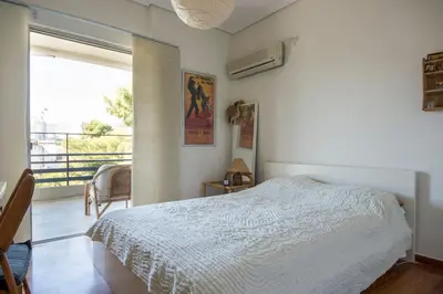 a bedroom with a bed and a large window at Varkiza Apartment in Varkiza