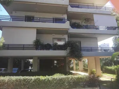 a large white building with plants on the balconies at Varkiza Apartment in Varkiza
