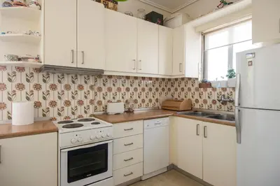 a kitchen with white cabinets and a stove top oven at Varkiza Apartment in Varkiza