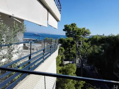 a balcony with a view of a street and the ocean at Varkiza Apartment in Varkiza