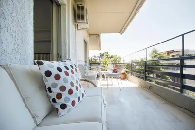 a white couch sitting on a balcony with a view at Varkiza Apartment in Varkiza