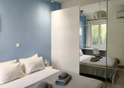 a bedroom with two beds and a mirror at KYMA Apartments - Athens Acropolis 5 in Athens