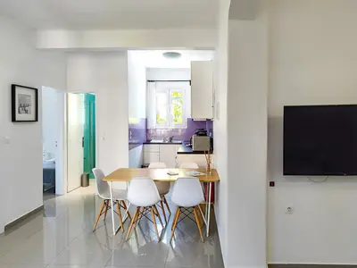 a kitchen and dining room with a table and chairs at KYMA Apartments - Athens Acropolis 5 in Athens