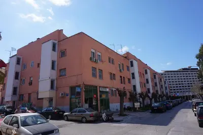 an orange building with cars parked in a parking lot at KYMA Apartments - Athens Acropolis 5 in Athens