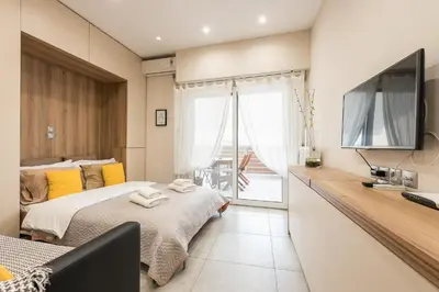 a bedroom with a bed and a flat screen tv at Athens Heart Design Studio in Athens