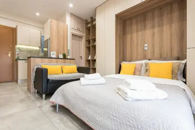a bedroom with a large bed with yellow pillows at Athens Heart Design Studio in Athens