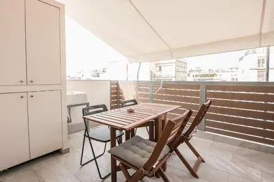 a wooden table and chairs on a balcony at Athens Heart Design Studio in Athens