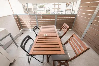 a wooden table and chairs on a balcony at Athens Heart Design Studio in Athens