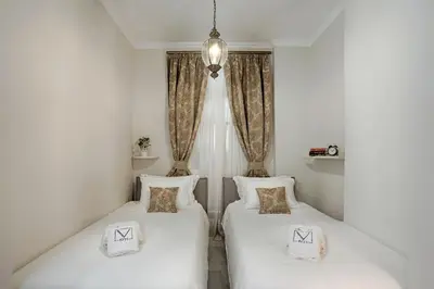 two twin beds in a room with a window at V1935 Luxurious Apartments in Athens