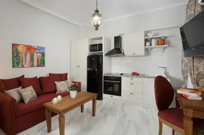 a living room with a red couch and a kitchen at V1935 Luxurious Apartments in Athens