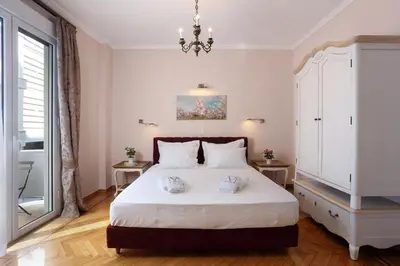 a bedroom with a bed and a chandelier at V1935 Luxurious Apartments in Athens