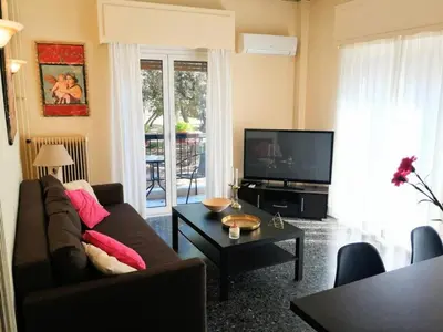 a living room with a couch and a flat screen tv at Elegant apartment in Acropolis with roof garden in Athens