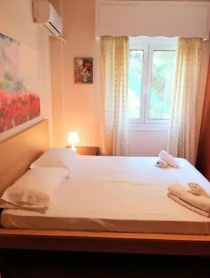 a bedroom with a large bed with a window at Elegant apartment in Acropolis with roof garden in Athens