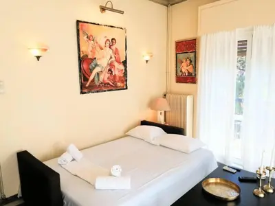 a bedroom with a bed and a desk and a painting at Elegant apartment in Acropolis with roof garden in Athens