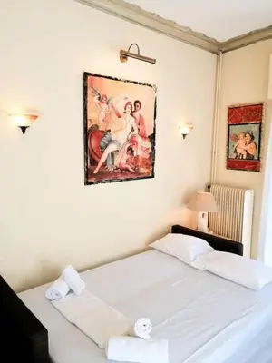 a bedroom with a bed and a painting on the wall at Elegant apartment in Acropolis with roof garden in Athens