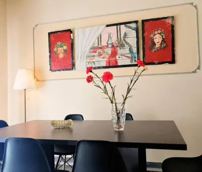 a table with a vase with red flowers on it at Elegant apartment in Acropolis with roof garden in Athens