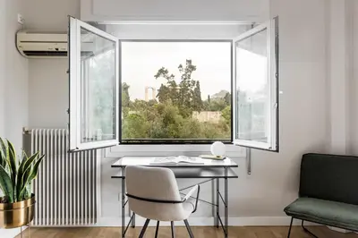 a window in a room with a desk and a chair at Zeus Temple view 2BD Apartment by UPSTREET in Athens