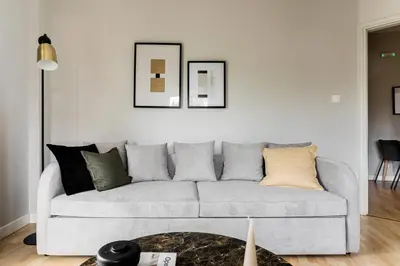 a white living room with a gray couch with pillows at Zeus Temple view 2BD Apartment by UPSTREET in Athens
