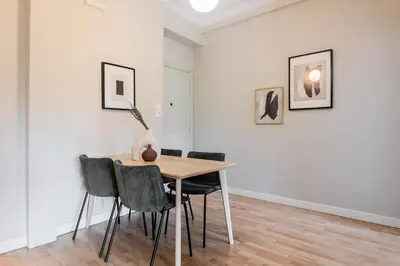 a dining room with a table and chairs in a white room at Zeus Temple view 2BD Apartment by UPSTREET in Athens