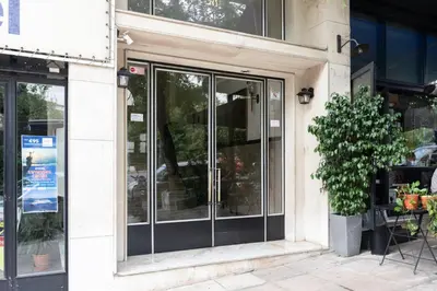 a store front with glass doors on a building at Zeus Temple view 2BD Apartment by UPSTREET in Athens