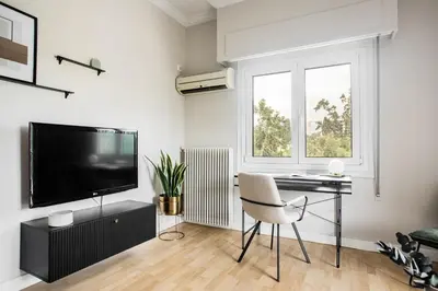 a living room with a desk and a television at Zeus Temple view 2BD Apartment by UPSTREET in Athens