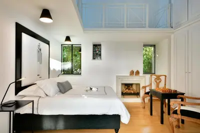 a bedroom with a bed and a fireplace at ALDIS MANSION by K&K in Athens