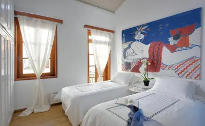 two beds in a room with a painting on the wall at ALDIS MANSION by K&K in Athens