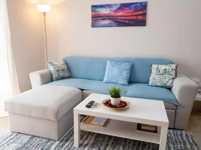 a living room with a blue couch and a coffee table at DaMa Blue in Saronida