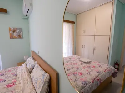 a bedroom with a bed and a mirror at DaMa Blue in Saronida