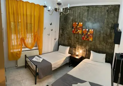 a room with two beds and a window at Stone house under Acropolis in Athens