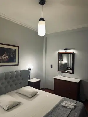 a bedroom with a bed and a mirror at Alfa Hotel in Piraeus