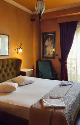 a hotel room with a bed and a chair at Alfa Hotel in Piraeus