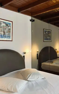a bedroom with a bed and a mirror on the wall at Alfa Hotel in Piraeus