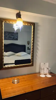 a mirror on top of a dresser in a bedroom at Alfa Hotel in Piraeus