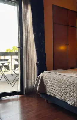 a bedroom with a bed and a sliding glass door at Alfa Hotel in Piraeus